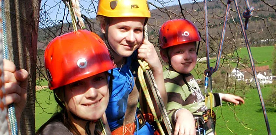 Kinder auf einem Kletterbaum im Waldpiraten-Camp